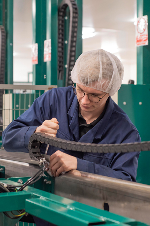 A male Tangmere Airfield Nursery employee working as a mechanic.